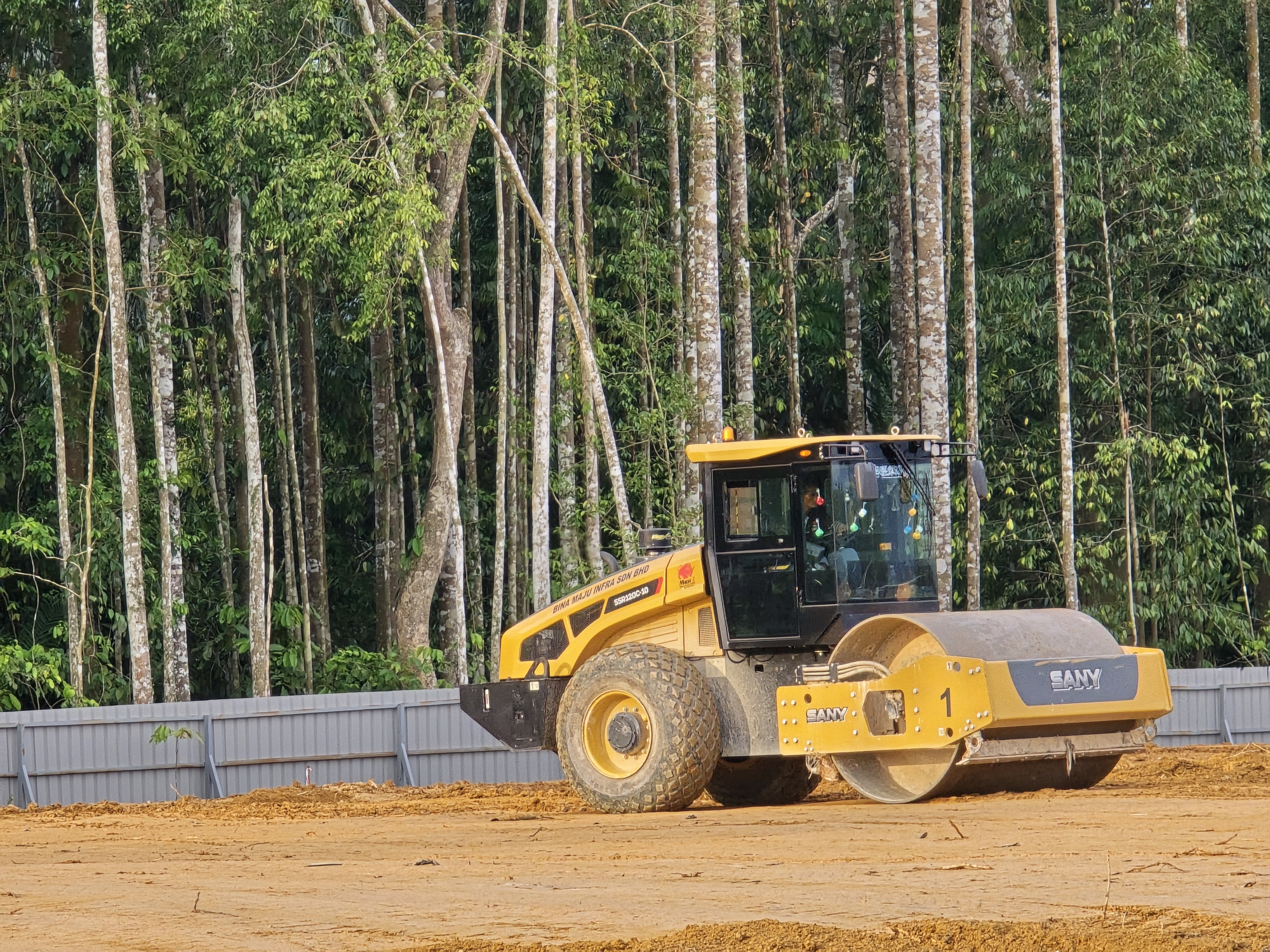 Roller compacting soil in layers to build a stable earthwork grade.