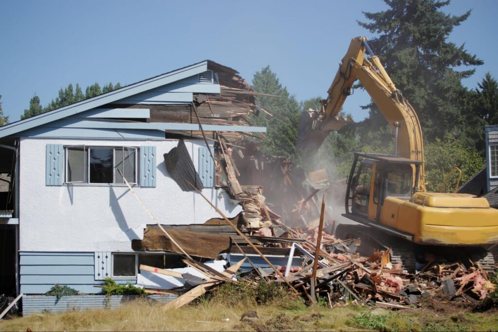 An excavator tears down a two-story house during a residential demolition project in Boise.